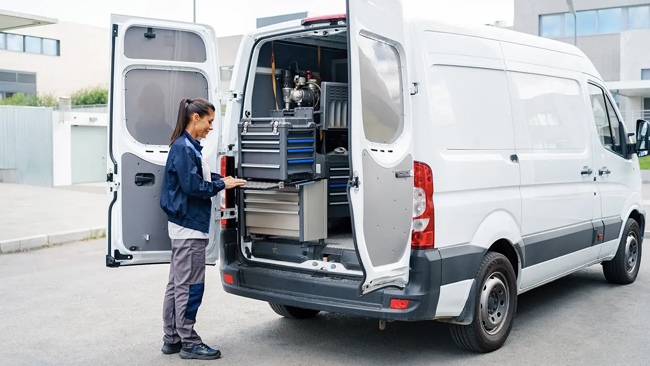 Van de trabajo con puertas traseras de doble hoja abiertas para acceder a equipos