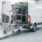 Van de trabajo con una rampa desplegada para movilizar un carro con ruedas