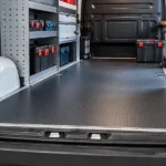 Sobrepiso protector instalado en una van de trabajo equipada con mobiliario y herramientas
